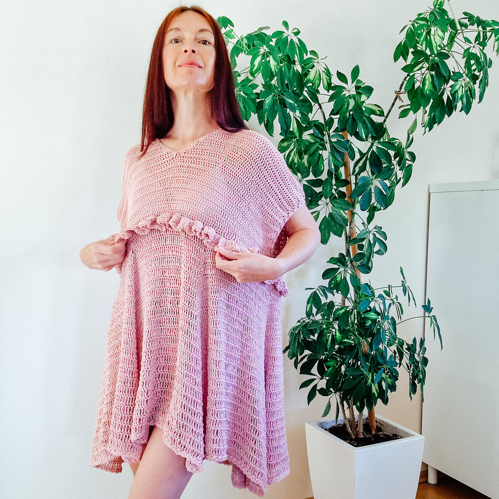 Loops Only blush ruffle summer dress hanging on a wooden hanger, lightweight fabric with floral pattern and ruffled neckline.