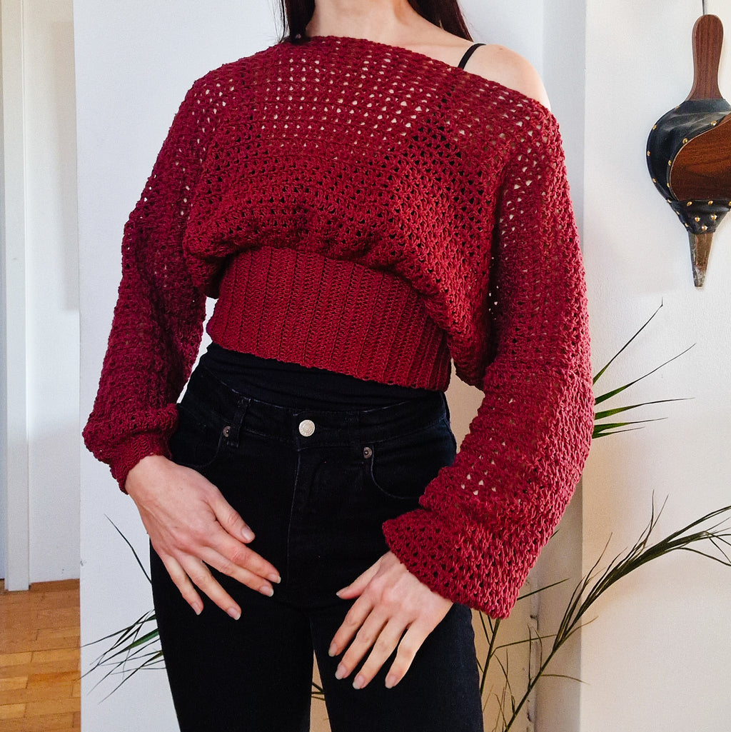 Crochet cropped bishop sleeve sweater by Loops Only featuring textured knit and wide bishop sleeves on a neutral background.