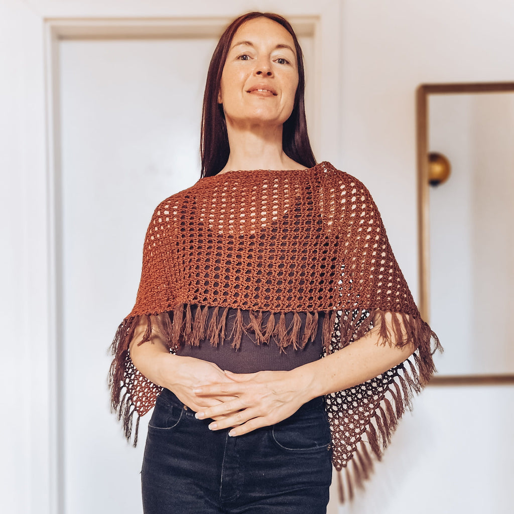 Loop Only Ember Fringe Poncho shawl with fringed edges, cozy knit fabric, and warm autumn colors displayed on a mannequin.