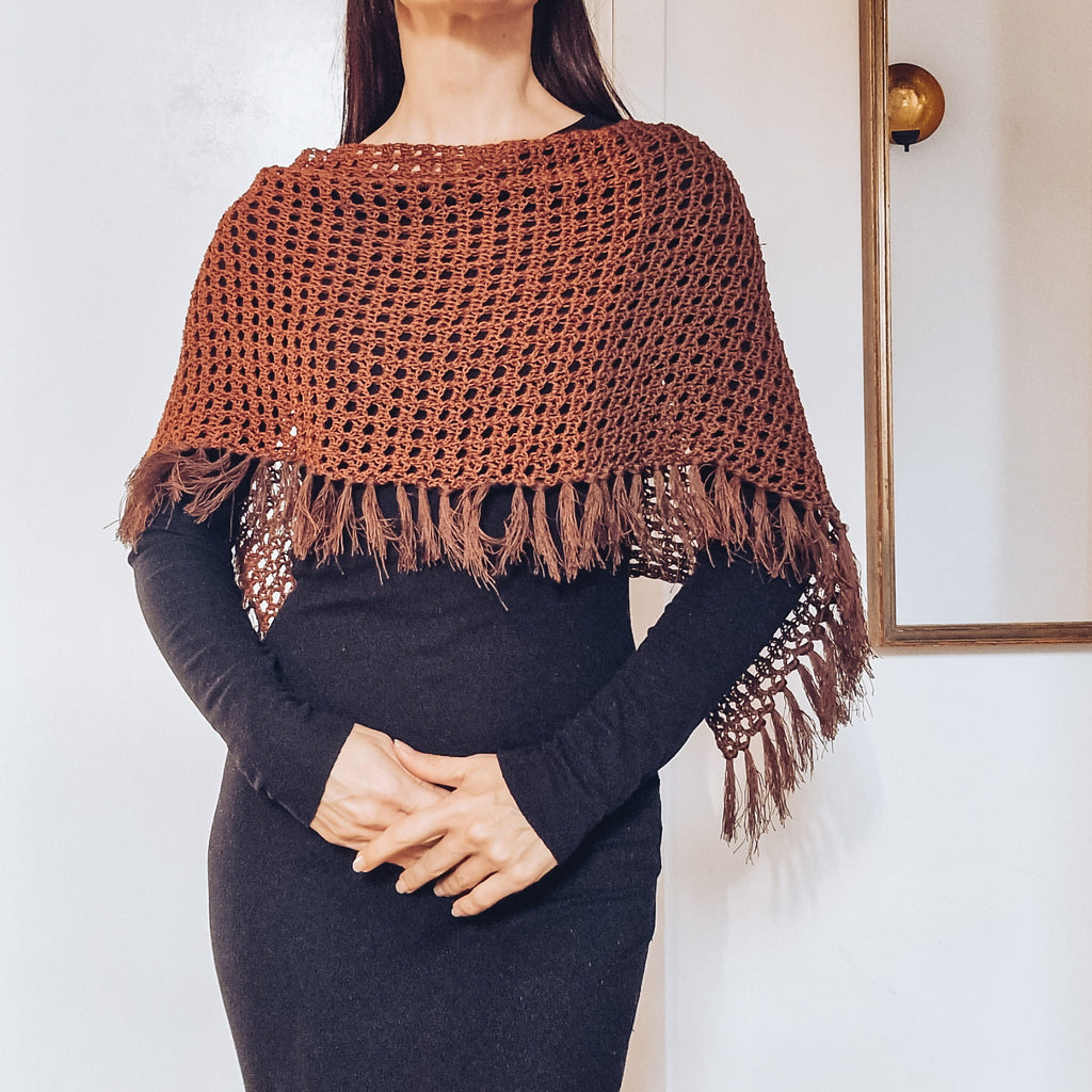 Loops Only Ember Fringe Poncho shawl with fringed edges, cozy knit fabric, and warm orange-toned color, versatile for layering.