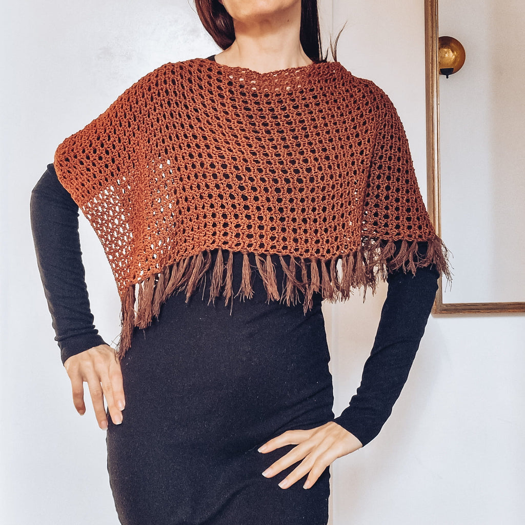 Loops Only Ember Fringe Poncho shawl with fringe detailing, cozy and stylish in warm ember color, draped over a mannequin.